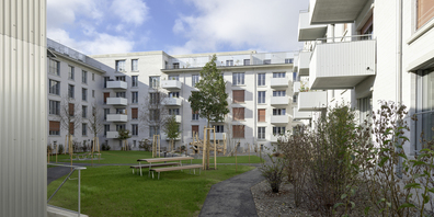 Beide C-förmige Neubauten fassen je einen dicht bepflanzten Innenhof