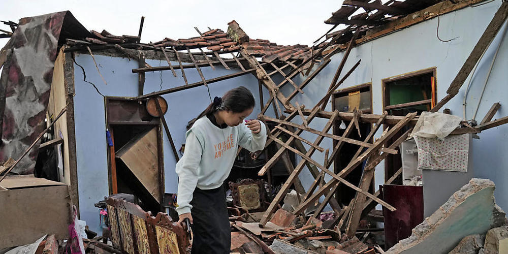 Eine Frau inspiziert ihr Haus, das bei einem Erdbeben in Cianjur schwer beschädigt wurde. Foto: Tatan Syuflana/AP/dpa