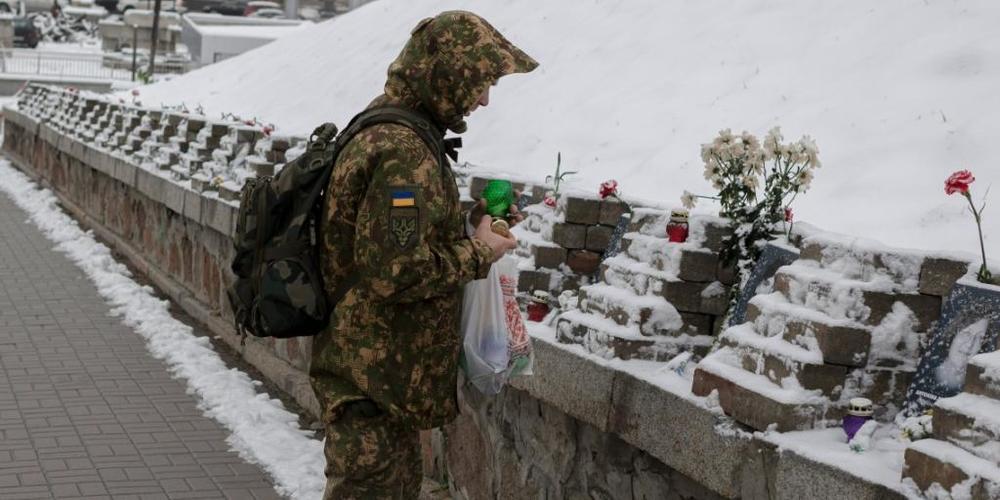 Ein ukrainischer Soldat gedenkt in Kiew den Menschen, die bei Zusammenstößen mit Sicherheitskräften auf dem Maidan-Platz im Jahr 2014 ums Leben kamen. Foto: Andrew Kravchenko/AP/dpa