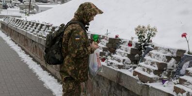 Ein ukrainischer Soldat gedenkt in Kiew den Menschen, die bei Zusammenstößen mit Sicherheitskräften auf dem Maidan-Platz im Jahr 2014 ums Leben kamen. Foto: Andrew Kravchenko/AP/dpa