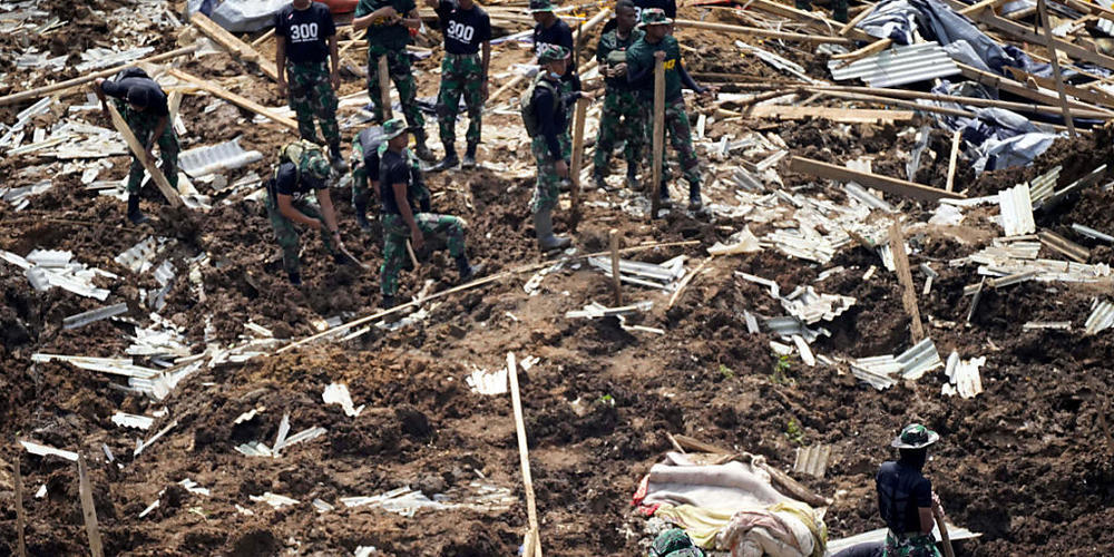Rettungskräfte suchen nach Opfern eines durch ein Erdbeben ausgelösten Erdrutsches. Foto: Tatan Syuflana/AP/dpa