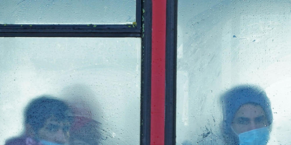 ARCHIV - Eine Gruppe von Menschen, bei denen es sich vermutlich um Migranten handelt, sitzt in einem Bus. Am 24.11.2021 starben mindestens 27 Migranten auf dem Weg nach Großbritannien, als ihr Boot im Ärmelkanal sank. Foto: Gareth Fuller/PA Wire/dpa