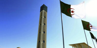 ARCHIV - Algerische Flaggen wehen neben der Großen Moschee in Algier. 49 Menschen wurden von einem Gericht in Algerien zum Tode verurteilt. Foto: Toufik Doudou/AP/dpa