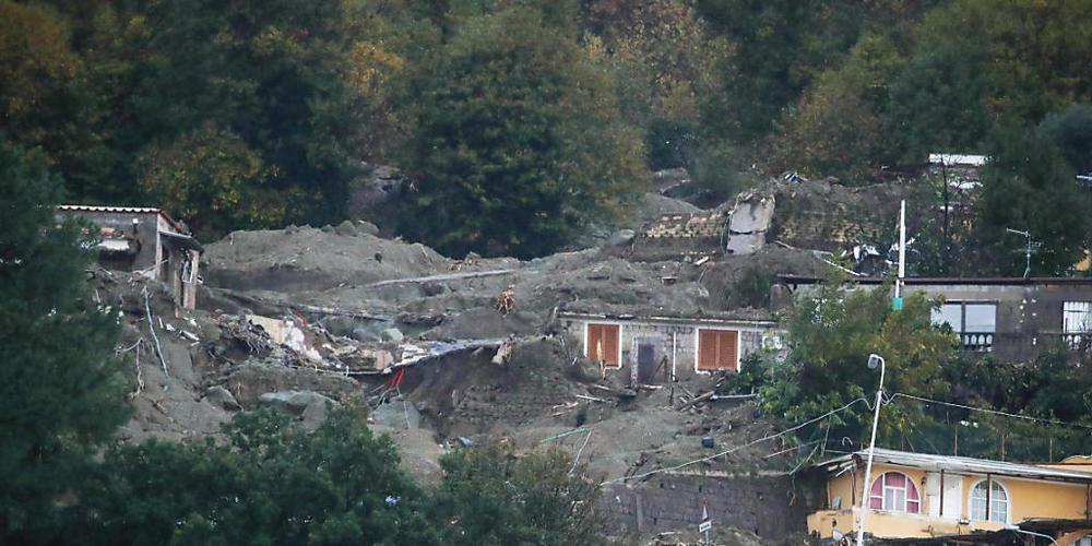 Ein Blick auf einen Hang mit Häusern, die durch Erdrutsche beschädigt wurden. Foto: Salvatore Laporta/AP/dpa