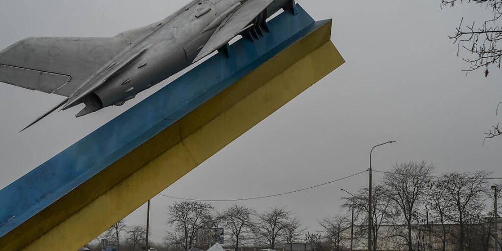 Autos fahren an der Skulptur eines Flugzeugs vorbei, während sie Cherson verlassen. Viele Zivilisten flüchten aus der südukrainischen Stadt. Foto: Bernat Armangue/AP/dpa