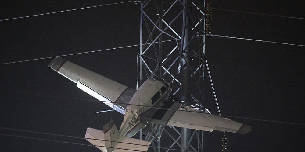 dpatopbilder - Bange Stunden für zwei Männer, die mit einem Kleinflugzeug in 30 Metern Höhe in einem Strommast festhängen. Foto: Tom Brenner/AP/dpa
