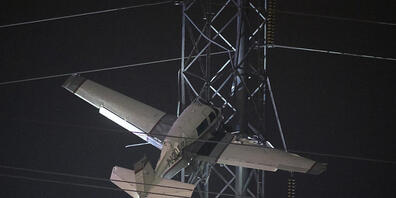 dpatopbilder - Bange Stunden für zwei Männer, die mit einem Kleinflugzeug in 30 Metern Höhe in einem Strommast festhängen. Foto: Tom Brenner/AP/dpa