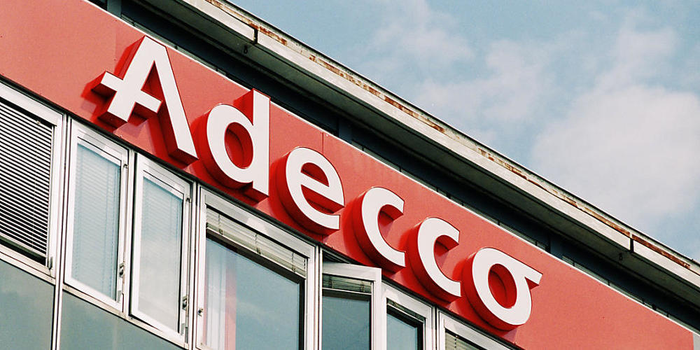 Immer mehr IT-Fachleute und solche in Ingenieursberufen fehlen in der Schweiz. (Logo der Stellenvermittlungsfirma Adecco in Lausanne/Archivbild)
