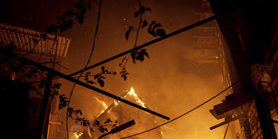Ein Haus brennt nach einem Angriff in Cherson. Foto: Evgeniy Maloletka/AP/dpa