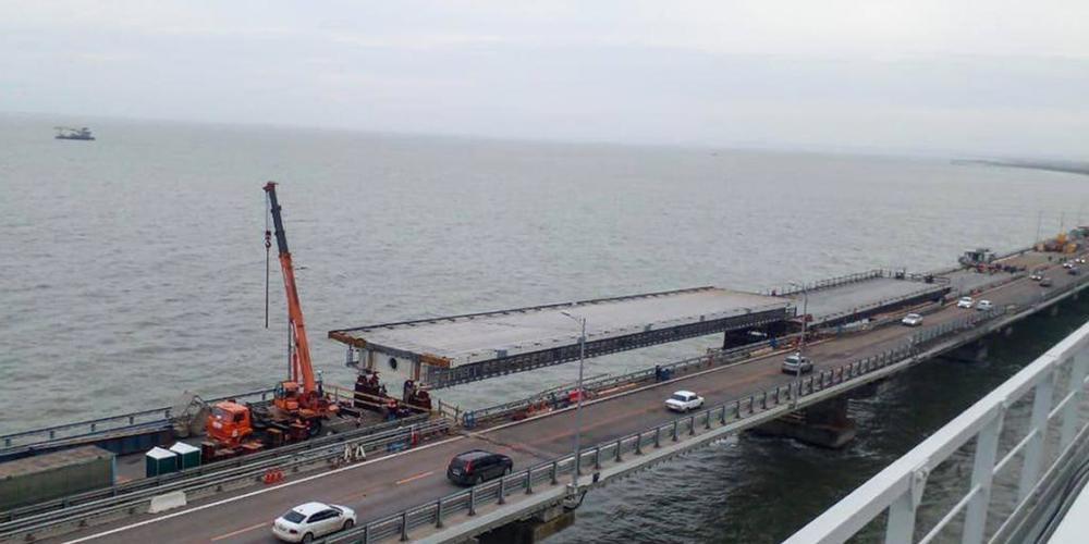 HANDOUT - Auf diesem von der Russischen Föderalen Straßenverkehrsbehörde (Rosavtodor) via AP veröffentlichten Foto reparieren Arbeiter während der Restaurierungsarbeiten unweit von Kertsch auf der Krim die Seite der beschädigten Spannweiten des St...