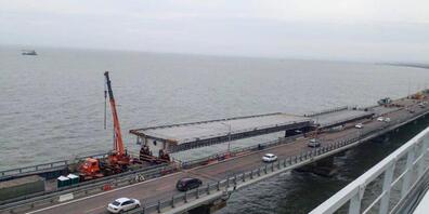 HANDOUT - Auf diesem von der Russischen Föderalen Straßenverkehrsbehörde (Rosavtodor) via AP veröffentlichten Foto reparieren Arbeiter während der Restaurierungsarbeiten unweit von Kertsch auf der Krim die Seite der beschädigten Spannweiten des St...