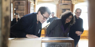 Der Theaterregisseur Milo Rau mit der in der St. Galler Stiftsbibliothek ausgestellten Mumie Schepenese. (Archivbild)