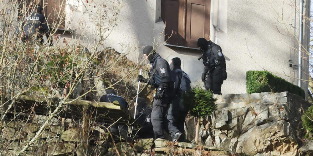 Einsatzkräfte der Polizei durchsuchen ein Gebäude in Thüringen. Foto: Bodo Schackow/dpa