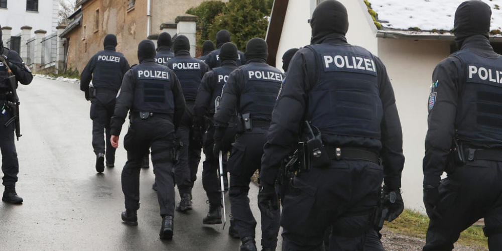 Einsatzkräfte der Polizei laufen zum Jagdschloss Waidmannsheil. Die Bundesanwaltschaft hat am Mittwochmorgen mehrere Menschen aus der sogenannten "Reichsbürgerszene" im Zuge einer Razzia festnehmen lassen. Foto: Bodo Schackow/dpa