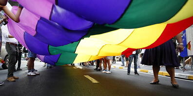 Regenbogenfahne in einem Strassenumzug. Der Nationalrat will Konversionsmassnahmen an jungen LGBTQ-Personen verbieten. (Themenbild)
