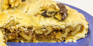 Eine Engadiner Nusstorte ist ein schlichter und doch sehr aromatischer Kuchen mit karamellisierten Walnüssen und Mürbeteig. 
