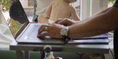 Ein Kinderarzt gibt auf einem Laptop Resultate der Untersuchung eines Säuglings ein. (Archivbild)