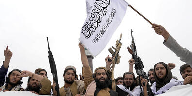 ARCHIV - Taliban-Kämpfer versammeln sich mit Fahnen, einem Banner und Gewehren. Foto: Ebrahim Noroozi/AP/dpa
