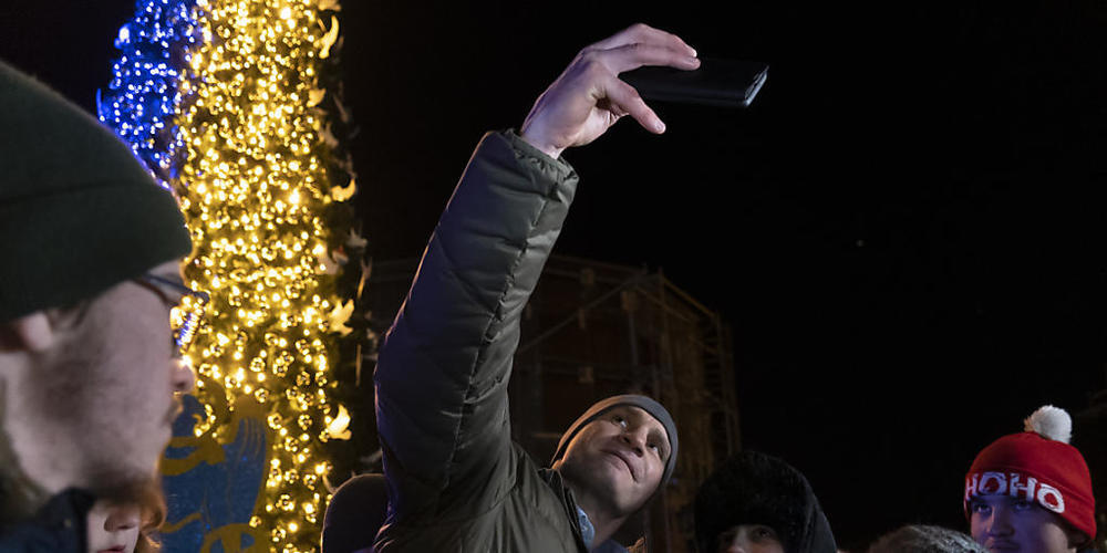Bei der Einweihung eines Weihnachtsbaumes in Kiew macht Bürgermeister Vitali Klitschko ein Selfie mit Unterstützern. Foto: Vasilisa Stepanenko/AP/dpa