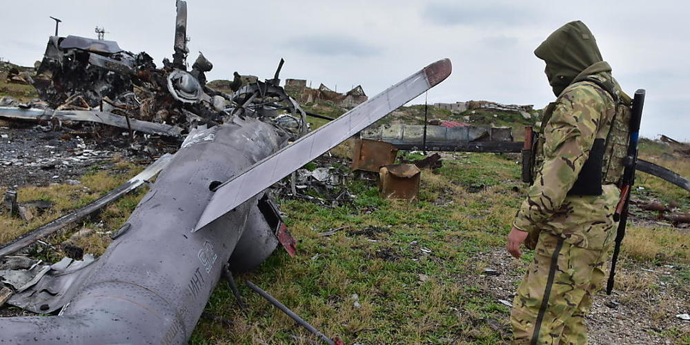 dpatopbilder - Ein ukrainischer Soldat betrachtet ein beschädigtes russisches Militärflugzeug. Foto: Michael Shtekel/AP/dpa