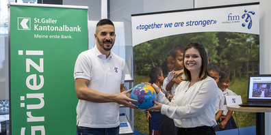 Beitrag zur Inklusion: Corinne Rupf, Kundenberaterin der St. Galler Kantonalbank, übergibt Cengiz Bicer, Assistent CEO der Stiftung FIM, symbolisch für die 500-fränkige Spende einen Fussball.