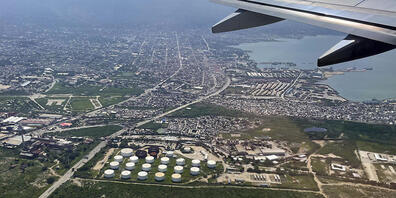 Ein Tanklager ist von einem Flugzeug aus in Port-au-Prince, Haiti, zu sehen. Foto: Ramon Espinosa/AP/dpa