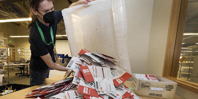 Ein Wahlhelfer bereitet die Auszählung der Stimmzettel aus King County vor. Foto: Ken Lambert/The Seattle Times/AP/dpa