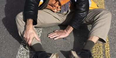 Ein Klimaaktivist klebt sich auf einer Strasse fest. Darf die Polizei seine Hand gewaltsam wegreissen, wenn ein Sanitätsfahrzeug durchfahren sollte? (Archivbild)