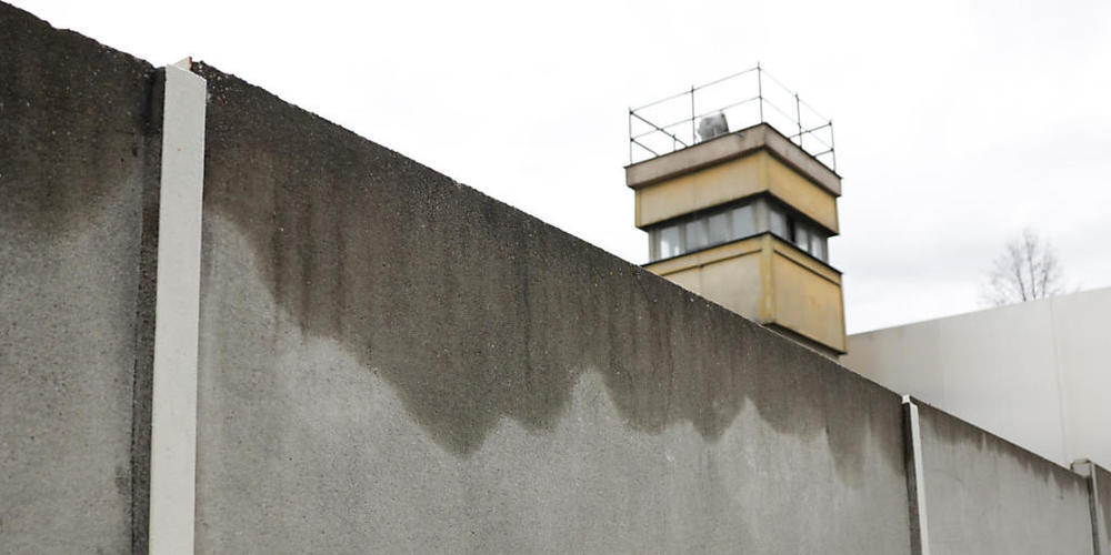 Rund 200 Schülerinnen und Schüler aus Deutschland, Frankreich und Norwegen haben Rosen in eine Spalte der einst trennenden Mauer gesteckt, von der noch Teile in der Gedenkstätte am originalen Standort stehen. Foto: Joerg Carstensen/dpa