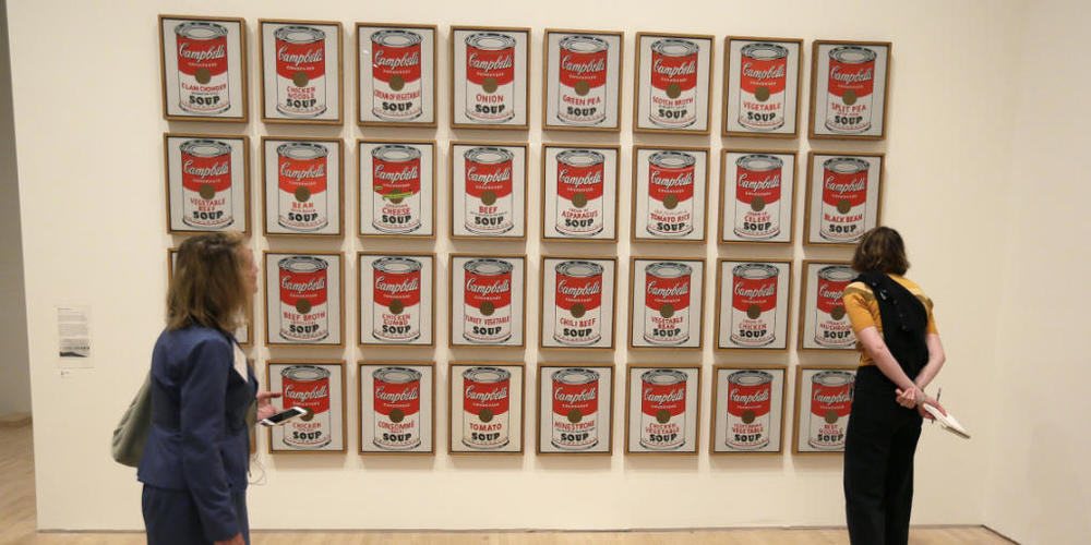 ARCHIV - Zwei Frauen betrachten das Pop-Art-Kunstwerk "Campbell's Soup Cans" von 1962 in der Ausstellung "Andy Warhol - From A to B and Back Again" in San Francisco. Foto: Eric Risberg/AP/dpa - ACHTUNG: Nur zur redaktionellen Verwendung im Zusamme...