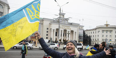 Ukrainer versammeln sich in der Innenstadt, um die Rückeroberung ihrer Stadt Cherson zu feiern. Foto: Yevhenii Zavhorodnii/AP/dpa