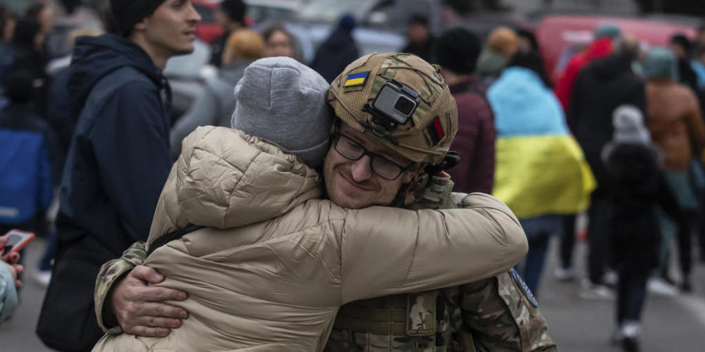 dpatopbilder - Eine Frau umarmt einen ukrainischen Offizier, als sie die Rückeroberung von Cherson, Ukraine, feiert. Foto: Yevhenii Zavhorodnii/AP/dpa