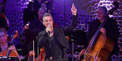 Anlässlich des 25. Jubiläums seiner Solo-Karriere gab Robbie Williams, britischer Sänger und Songwriter, zusammen mit dem Orchester der Neuen Philharmonie Frankfurt in der Elbphilharmonie ein mitreißendes Konzert. Foto: Georg Wendt/dpa - ACHTUNG: ...
