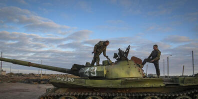 Ukrainische Soldaten inspizieren einen beschädigten russischen Panzer in dem kürzlich zurückeroberten Dorf Tschornobajiwka in der Nähe von Cherson. Foto: Efrem Lukatsky/AP/dpa