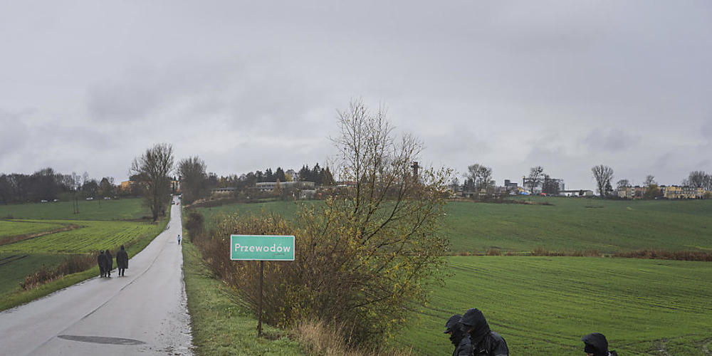 Polnische Polizisten suchen in der Nähe der Raketeneinschlagstelle nahe der Grenze ein Feld nach Wrackteilen ab. Foto: Evgeniy Maloletka/AP/dpa