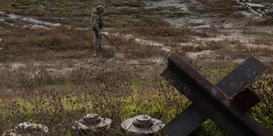 Ein ukrainischer Soldat sucht auf dem Feld eines kürzlich befreiten Dorfes am Rande von Cherson nach Minen. Foto: Bernat Armangue/AP/dpa