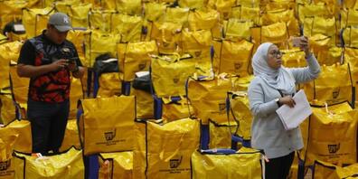 Beamte der Wahlkommission kontrollieren im malysischen Shah Alam die Wahlurnen, bevor sie in ein Wahllokal gebracht werden. Foto: Supian Ahmad/ZUMA Press Wire/dpa