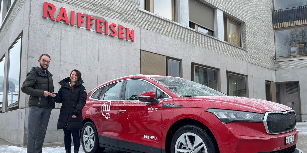 Sprichwörtlich voller Energie ins neue Jahr; Bankleitungsmitglied Tobias Bruderer weiht zusammen mit Mobility-Vertreterin Magdalena Balogh den neuen Standort samt Auto ein.