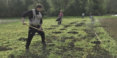 Mitglieder bringen Kompost auf dem Acker bei der Wynegg aus.