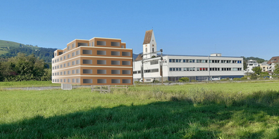 Das umstrittene Projekt links aus Sicht der erneuerten Seeanlage in Freienbach; rechts der bestehende Bau der Bruhin AG, hinten die Pfarrkirche Freienbach, der Friedhof verschwindet hinter dem Neubau.