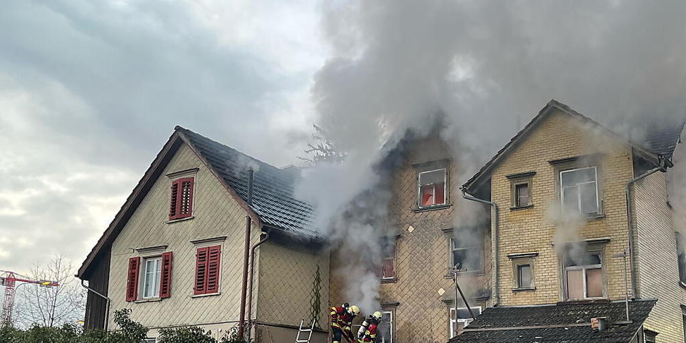 Feuerwehrleute löschen das unbewohnte ältere Einfamilienhaus in Altstätten SG, in dem aus unbekanntem Grund ein Brand ausgebrochen war.
