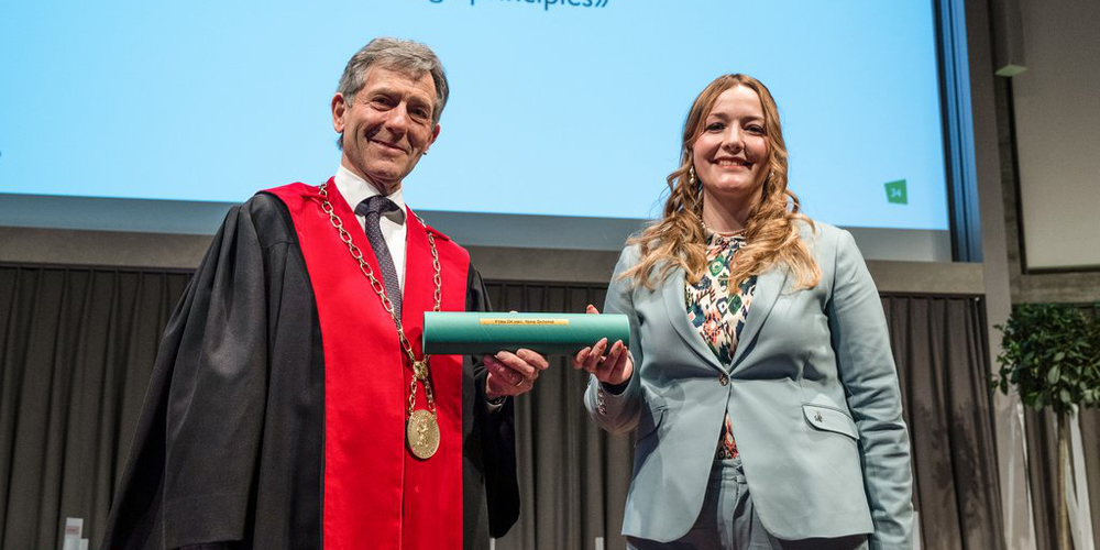 HSG-Rektor Bernhard Ehrenzeller übergibt der Doktorandin das Diplom