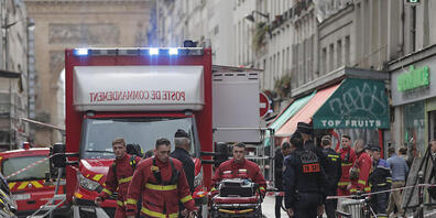 Feuerwehrsanitäter arbeiten am Freitag am Tatort in Paris. Foto: Lewis Joly/AP/dpa