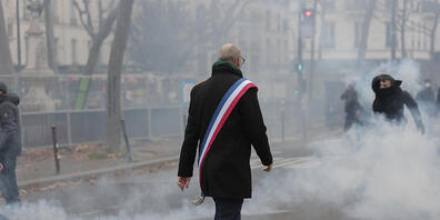 Pascal Troadec, Bürgermeister von Grigny, geht in einer Tränengaswolke während eines Protestes nach Schüssen in einem Kulturzentrum in Paris. Foto: Lewis Joly/AP/dpa