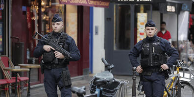Ein Polizeibeamter bewacht den Tatort, nachdem in der Rue d'Enghien im 10. Arrondissement Schüsse abgefeuert wurden. Bei Schüssen in Paris sind mehrere Menschen getötet und verletzt worden. Foto: Lewis Joly/AP/dpa