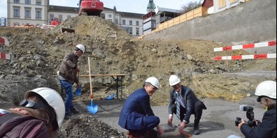 Dominik Diezi (Mitte links), Chef des Departements für Bau und Umwelt, und Walter Schönholzer, Chef des Departements für Inneres und Volkswirtschaft, versenken die Zeitkapsel im Boden unter dem künftigen Ergänzungsbau.