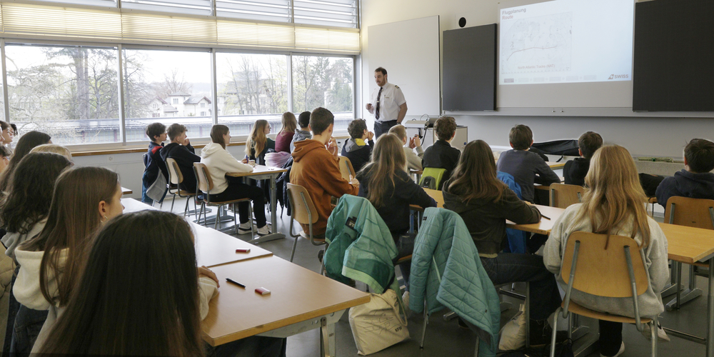 Blick ins Schulzimmer, wo ein Swiss-Pilot Schülerinnen und Schülern das Thema «Technik im Pilotenberuf: höher, schneller, weiter» nahebringt. 