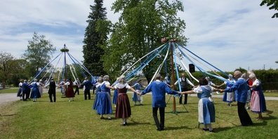 Beschwingt um den Maibaum tanzen.