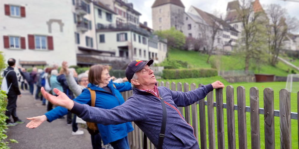 Meditativ und gemeinschaftlich. Das Dehnen am Zaun mit Blick auf den Schlosshügel.
