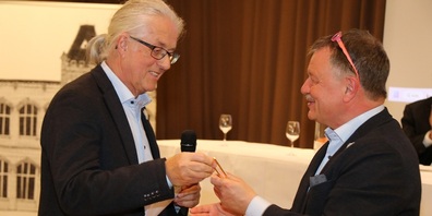 Guido Helbling, Chef SGF’22-Musikkommission, überreicht Rolf Heft die «Golden Stimmgabel». 